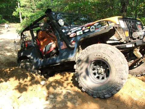 1996 Ford Bronco - Off-road vehicle stuck in mud, front tire visible.