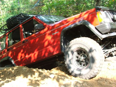 1996 Ford Bronco - A red SUV with significant damage to its front end is pictured in an outdoor setting.