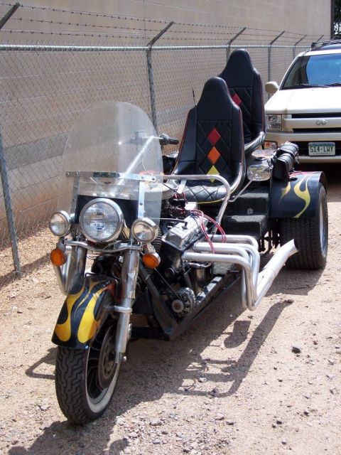 1972 Ford Ranchero - This custom trike features a V8 engine and flame graphics, with an SUV visible in the background.
