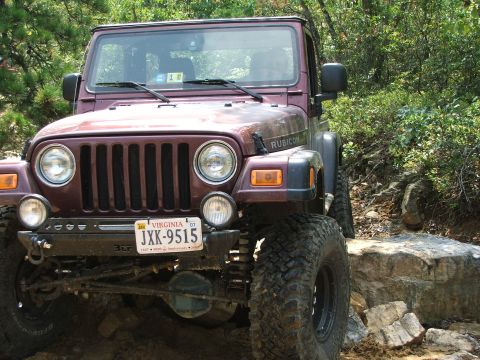 1996 Ford Bronco - Jeep Wrangler Rubicon navigating a challenging rocky off-road course.
