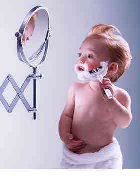 1999 Ford Crown Victoria - A baby pretends to shave in front of a mirror.