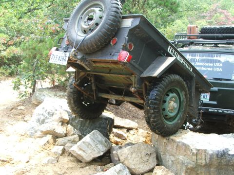 1996 Ford Bronco - An SUV and trailer navigate a rocky off-road course, demonstrating their capabilities.