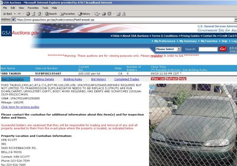 1999 Ford Crown Victoria - A 1993 Ford Taurus is shown behind a fence, with visible damage and wear.