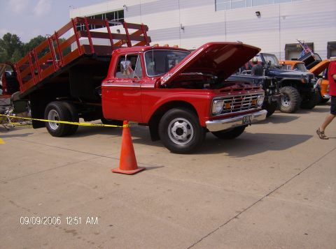 1970 Ford Ranchero - A red flatbed truck from the mid-1960s is displayed with its hood open.
