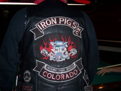 1972 Ford Ranchero - A person wears a black leather vest adorned with 'Iron Pigs MC' and 'Colorado' patches, seen at a charity event.