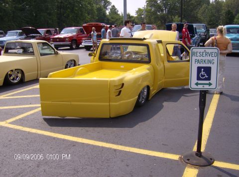 1970 Ford Ranchero - Custom yellow pickup truck with a lowered stance and modified body panels is parked in a lot with other vehicles.