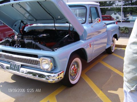 1970 Ford Ranchero - This light blue pickup truck, likely from the early 1960s, is displayed with its hood open, revealing the engine compartment.