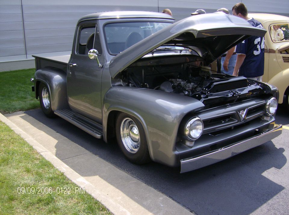 Gray custom 1950s Ford F-100 pickup with hood open at a car show