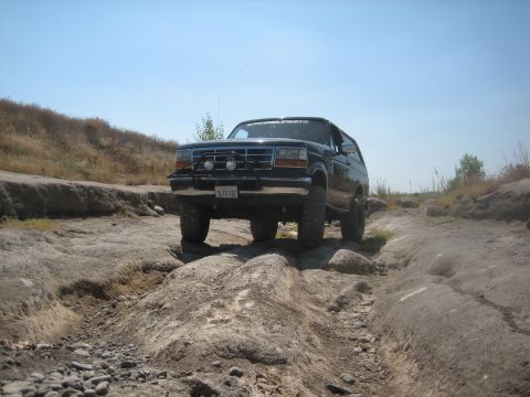 1995 Ford Bronco - A Ford Bronco navigates a challenging off-road course with rocky terrain and steep inclines.