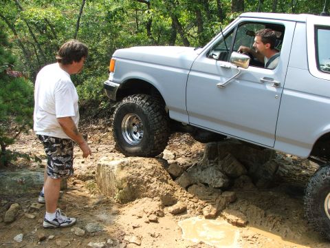 1996 Ford Bronco - Bronco tackling an obstacle on a dirt trail.