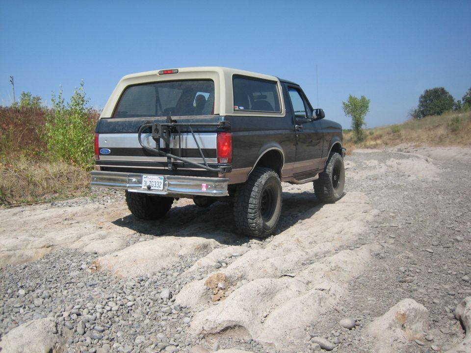 Ford Bronco on a rocky trail, spare tire mounted on the back