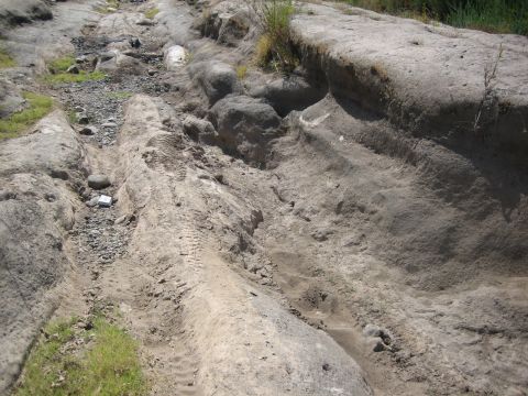 1995 Ford Bronco - Tire tracks mark a path through a , eroded terrain, suggesting off-road vehicle use.