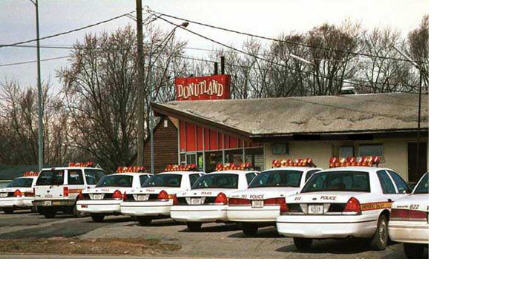 Rear view of 1999 Ford Crown Victoria police cars parked in front of Donutland
