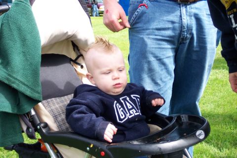 1979 Ford Bronco - A baby with a mohawk hairstyle sits in a stroller, wearing a GAP sweatshirt.