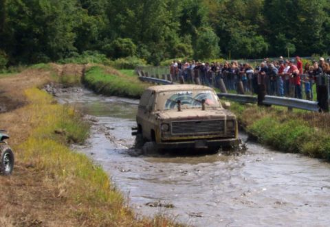 1979 Ford Bronco - Mud bogging event with multiple vehicles and spectators.
