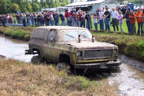 1979 Ford Bronco - Mud bogging event features a 1979 Ford Bronco navigating a muddy track with spectators observing.