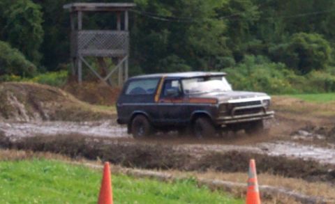 1979 Ford Bronco - This Ford Bronco navigates a muddy track, kicking up dirt as it goes.