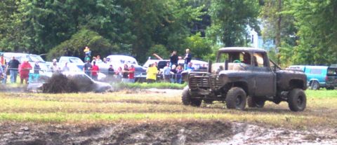 1979 Ford Bronco - A lifted truck sits in a muddy field while spectators watch another vehicle struggle in the mire.