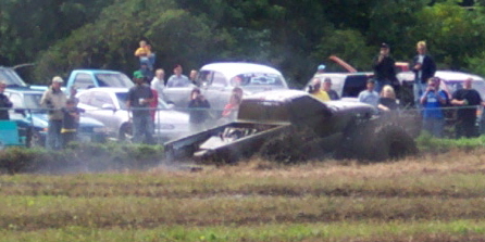 1979 Ford Bronco - A vehicle participates in a mud bogging event, with onlookers and other cars present.