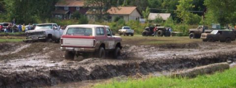 1979 Ford Bronco - A 1978 Ford Bronco navigates a muddy track alongside other vehicles.