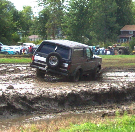 1979 Ford Bronco - Ford Bronco navigates a muddy track during an off-road event.