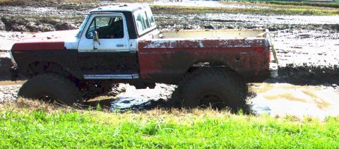 1979 Ford Bronco - This heavily modified 1978 Ford Bronco is stuck deep in the mud, with only its tires and lower body visible.