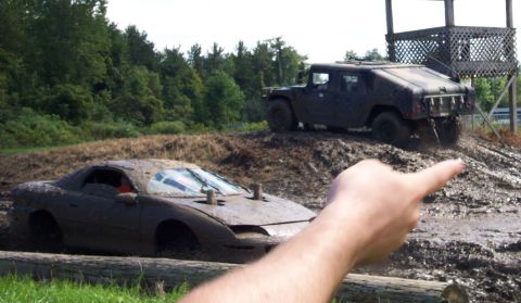 1979 Ford Bronco - A sports car is stuck in the mud while a Humvee navigates the terrain behind it.
