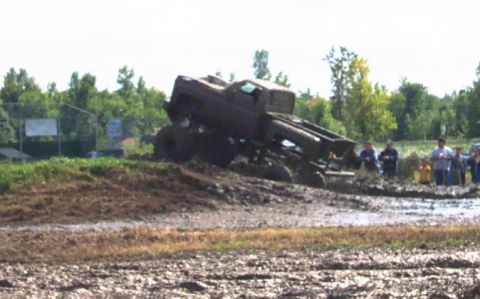 1979 Ford Bronco - A lifted truck is stuck in thick mud during a mud bogging event.