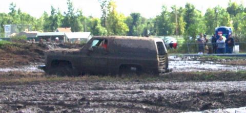 1979 Ford Bronco - This mud-covered SUV is stuck deep in the mud during an event. The vehicle's body style suggests it is from the late 1970s or early 1980s.