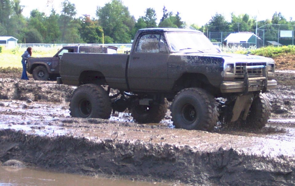 Lifted pickup truck stuck in mud with another vehicle behind it