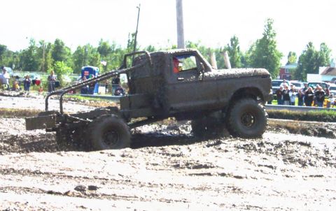 1979 Ford Bronco - This heavily modified 1979 Ford F-Series truck navigates a mud bog, its body caked in mud.
