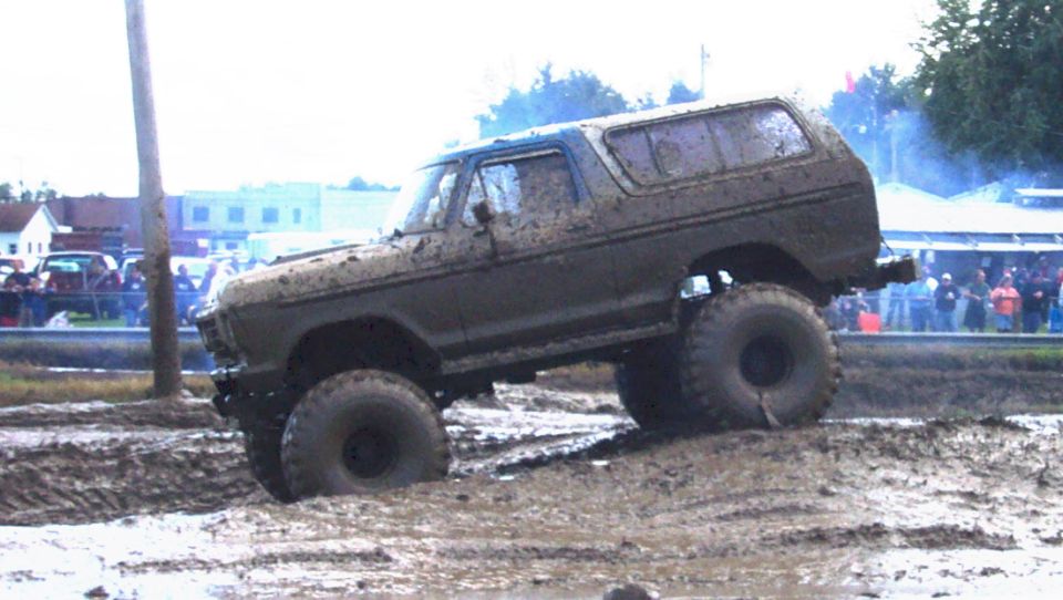 Mud-covered 1978 Ford Bronco with large tires in a mud pit