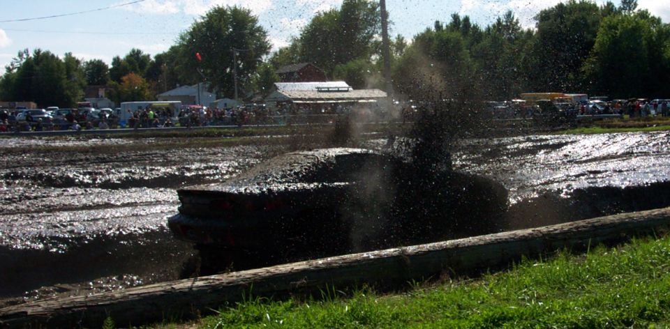 Dark 1978 Ford Bronco stuck in mud, splashing water