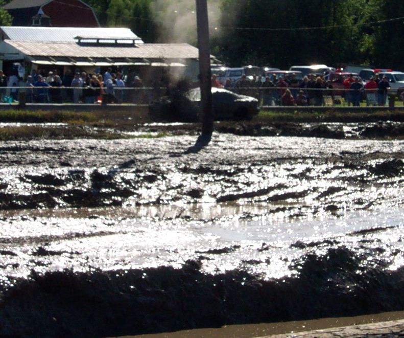 Mud bogging scene with a vehicle emitting smoke