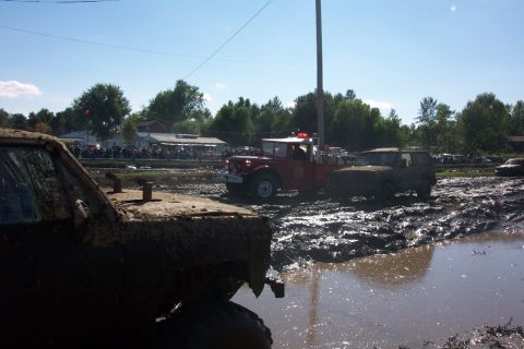 1979 Ford Bronco - Vehicles navigate a muddy track during an event, with a crowd gathered to watch the action.