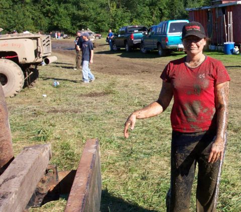 1979 Ford Bronco - A woman covered in mud stands in a field with multiple vehicles, suggesting a mud bogging event.