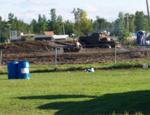 1979 Ford Bronco - Modified truck participating in a mud bogging event with spectators and facilities visible.