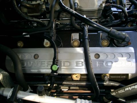 2003 Mercury Marauder - The engine bay shows a silver cover with 'POWERED BY FORD' inscribed on it.