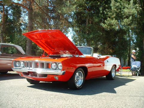 2000 Ford Crown Victoria - This orange convertible, likely a 1970 or 1971 Plymouth Barracuda, is displayed with its hood up at an outdoor event.
