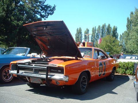 2000 Ford Crown Victoria - This iconic orange Dodge Charger, known as the General Lee, is displayed with its hood up at an outdoor car show.
