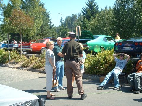 2000 Ford Crown Victoria - A gathering of people at a car show, with several classic and modern vehicles on display.