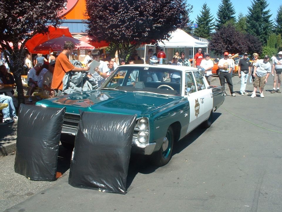 Green and white 1967 Plymouth Fury I Sheriff unit with black bags on front