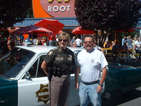 2000 Ford Crown Victoria - A King County Sheriff's Department vehicle is shown with two individuals posing beside it.