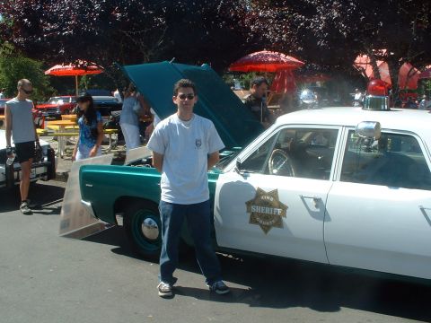2000 Ford Crown Victoria - A vintage King County Sheriff's car is displayed at an outdoor event with other vehicles and people present.
