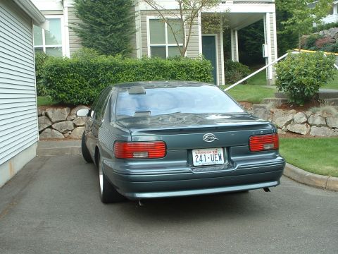 2000 Ford Crown Victoria - Rear view of a dark green Chevrolet Impala parked in a driveway next to a house.