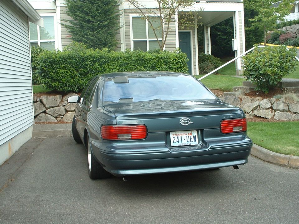 Dark green Chevrolet Impala parked in driveway, rear view. Washington license plate 241-UEW