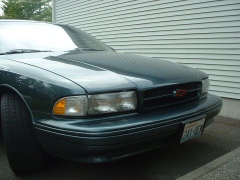 2000 Ford Crown Victoria - Front view of a dark green 1994 Chevrolet Impala, a red Chevrolet emblem on the grille and a Washington license plate.