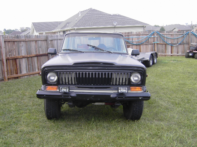 Black Jeep Wagoneer front view with vertical grille and round headlights