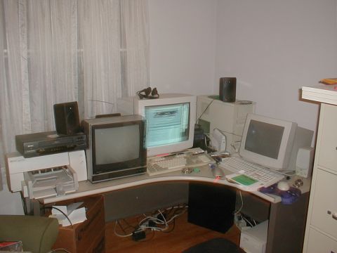 1999 Ford Crown Victoria - A cluttered computer workstation with vintage electronics and office supplies.