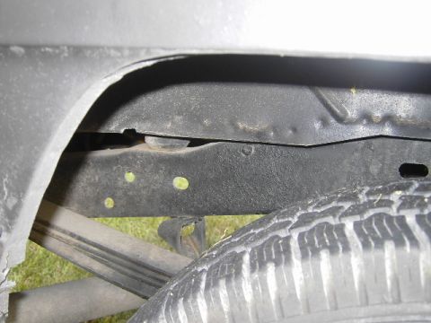 1977 Jeep Wagoneer - This photo shows a close-up view of the undercarriage of a vehicle, focusing on the frame and tire.